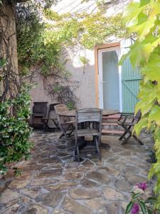 a patio with chairs and a table and a door at La Villa des Restanques in Carry-le-Rouet