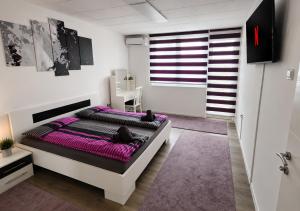 a bedroom with a large bed with purple sheets at Stan na dan Bosanska Krupa in Bosanska Krupa