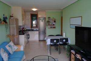 a kitchen and living room with a table and chairs at PLAYASDEBARREIROs in San Miguel de Reinante