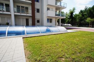 a swimming pool in a yard next to a building at Laguna Beach Apartmanok in Siófok