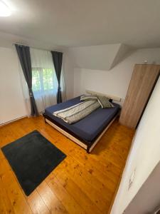 a bedroom with a bed and a wooden floor at Cabana Blaga in Şuncuiuş