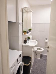 a white bathroom with a toilet and a sink at Stan na dan Bosanska Krupa in Bosanska Krupa +6 photos