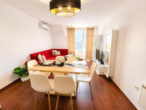 a dining room with a table and chairs and a couch at One-Bedroom flat Meden Rudnik zone B in Burgas