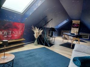 a living room with a blue wall at Love Room avec Jacuzzi Privatif Loft Sensation Romantique in Renwez