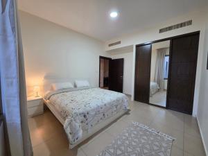 a bedroom with a bed and a large mirror at Spacious Abdoun 2BR with private garden & pool access in Amman +5 photos