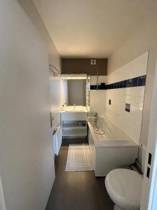 a bathroom with a toilet and a tub and a sink at Studio le petit cozy in Nancy