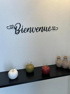 a black shelf with three apples and vases on it at Studio le petit cozy in Nancy