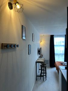 a living room with a table and a desk at Studio le petit cozy in Nancy