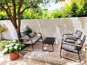two chairs and a table on a patio at Bugenvilija in Duće