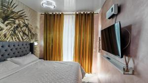 a bedroom with a bed and a flat screen tv at Onix Home Love 203 in Mamaia Sat/Năvodari