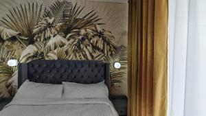a bedroom with a bed and a mural of plants at Onix Home Love 203 in Mamaia Sat/Năvodari +17 photos