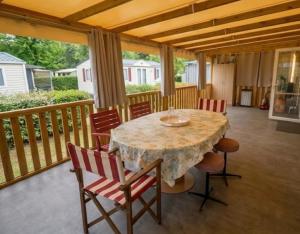 a porch with a table and chairs on a deck at Le Cocon d'Ambon in Ambon +6 photos