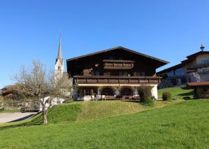 a large building on a hill with a church at Pension Anneliese in Schwendt +17 photos