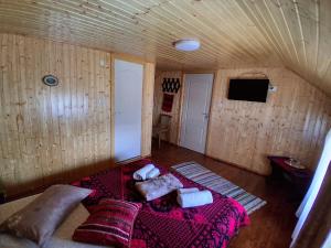 a room with a bed in a wooden room at Casa Faurului in Valea Faurului +57 photos