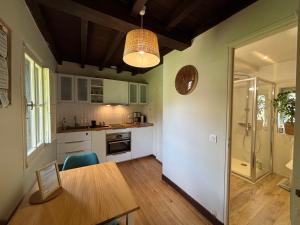 a kitchen with a table and a dining room at La dépendance in Luchon