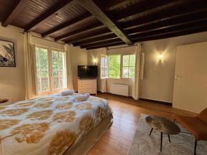 a bedroom with a large bed and windows at La dépendance in Luchon