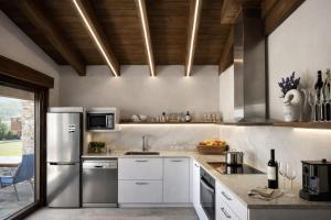 a kitchen with white cabinets and stainless steel appliances at La Era de Lardiés in Lardiés