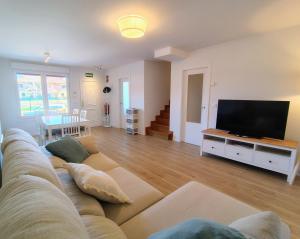a living room with a couch and a flat screen tv at Capricho de Rovacías in Comillas