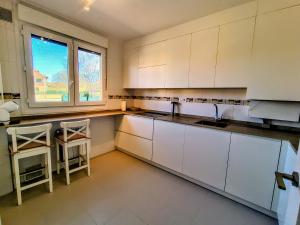 a kitchen with white cabinets and a window at Capricho de Rovacías in Comillas