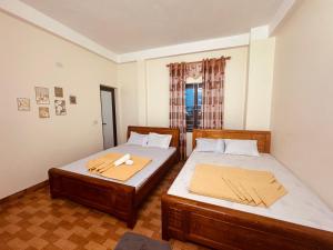 two beds in a small room with a window at Sơn Tùng House in Quang Ninh