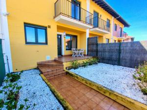 a yellow house with a bench in front of it at Capricho de Rovacías in Comillas