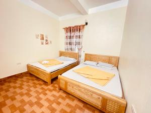 two beds in a small room with wooden floors at Sơn Tùng House in Quang Ninh +47 photos