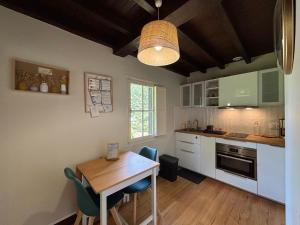 a kitchen with a wooden table and a dining room at La dépendance in Luchon