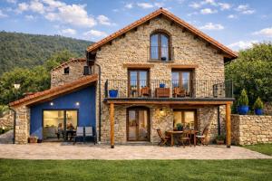 a large stone house with a table and chairs at La Era de Lardiés in Lardiés