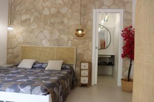 a bedroom with a bed and a stone wall at Residència Mediterrània Alguer in Alghero