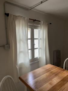 a dining room with a wooden table and a window at MAITEN Esquel in Esquel