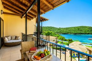 a balcony of a villa with a table with fruit at Ornella Beach Resort & Villas in Syvota