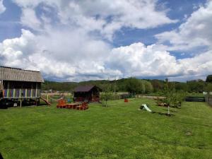 a yard with a playground with tables and a building at Casa Faurului in Valea Faurului
