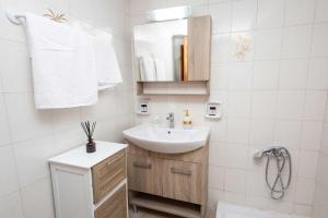 a white bathroom with a sink and a mirror at K&J House in Didyma +13 photos