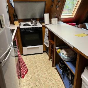 a kitchen with a stove and a counter top at Adorable Aframe in the White Mountains in Conway