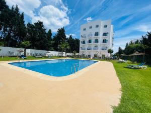 a swimming pool in front of a building at Cozy Studio Near Beach with Pool Access in Martil