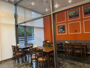 a dining room with wooden tables and chairs at Will Hotel in Baku