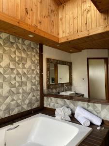 a bathroom with a large tub and a sink at Pousada Trinca Ferro in Bom Retiro +15 photos