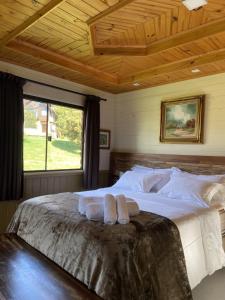 a bedroom with a large bed with towels on it at Pousada Trinca Ferro in Bom Retiro