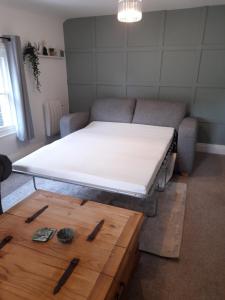 a bed in a living room next to a couch at Ironbridge town apartment in Ironbridge