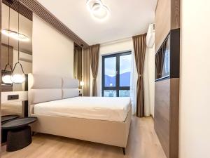 a bedroom with a white bed and a large window at SKY Apartment in Sarajevo +5 photos