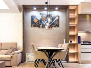 a dining room with a table and a painting on the wall at SKY Apartment in Sarajevo