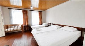 a bedroom with two beds and two windows at Tsatʼer Guest House in Tsatʼer