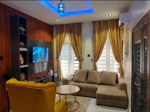 a living room with a couch and a table at OYO Serviced Apartment in Egbe