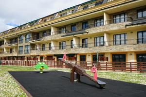 a large building with a playground in front of it at PLAYASDEBARREIROs in San Miguel de Reinante