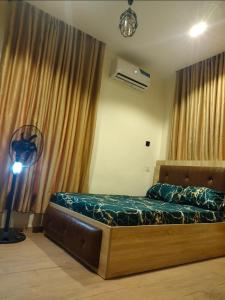 a bedroom with a bed and a fan and curtains at OYO Serviced Apartment in Egbe