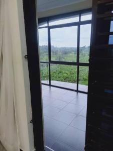 an open door to a room with a large window at Sunset Grove in Pakwach East
