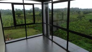 an empty room with a view of a field at Sunset Grove in Pakwach East