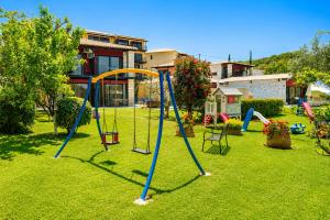 a yard with a playground with a swing set at Ornella Beach Resort & Villas in Syvota
