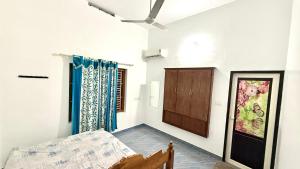 a bedroom with a bed and a ceiling fan at Mridanga Homestay in Iritti