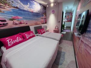 a bedroom with a large white bed with pink pillows at K Avenue by Stay & Unwind Suites in Donggongon +1 photo